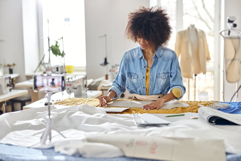 African-American Fashion Designer Works with Sewing Patterns and Fabric ...