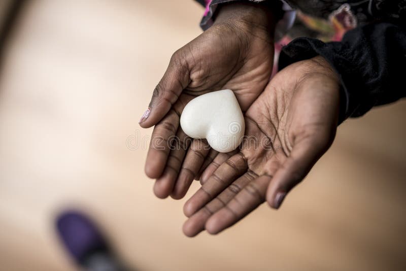 African-American girl hands holding a marble made heart