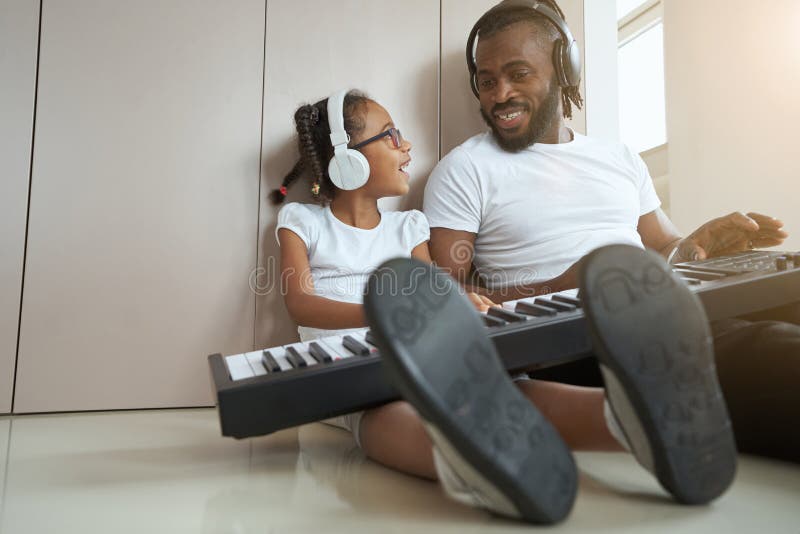 Un Père Afro-américain Adulte À Côté De Sa Fille Joue Du