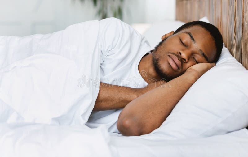 African American Guy Sleeping Resting In His Bed At Home Stock Photo