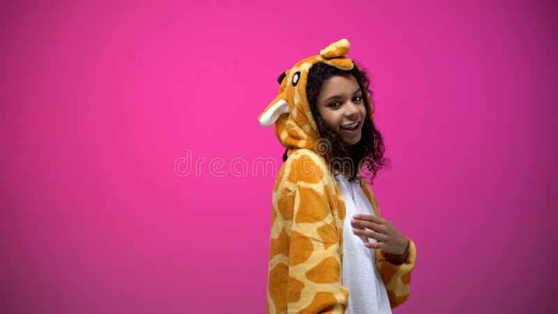 African american lady in funny giraffe costume posing on pink background, fun