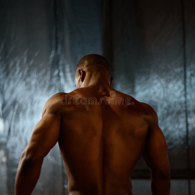 African american male body builder posing on a studio background. Back view stock photo