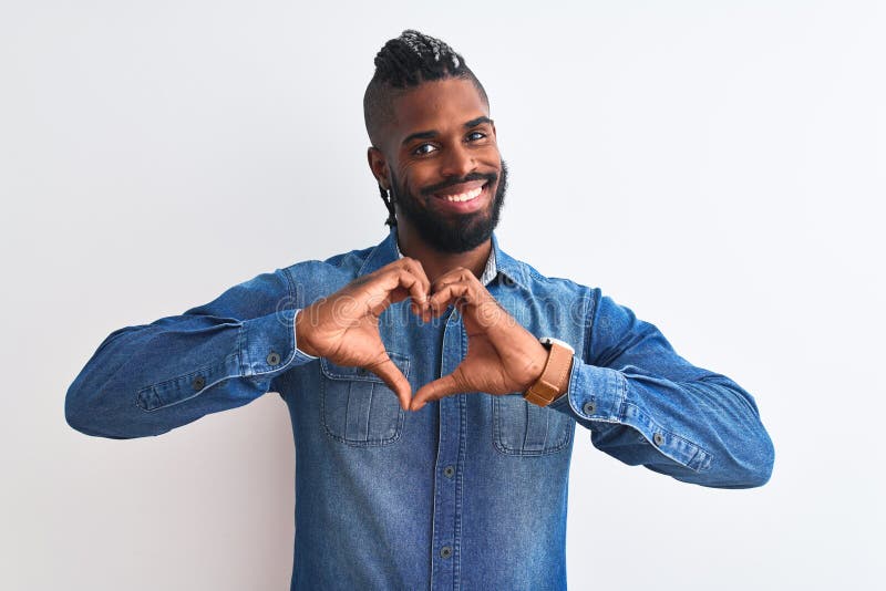 African american man with braids wearing denim shirt over isolated white background smiling in love doing heart symbol shape with