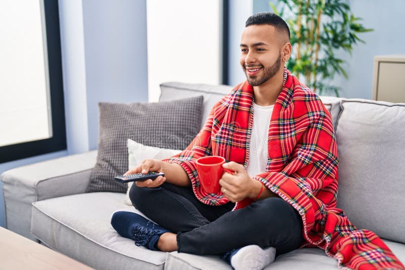 African American Man Drinking Coffee Watching Tv at Home Stock Photo