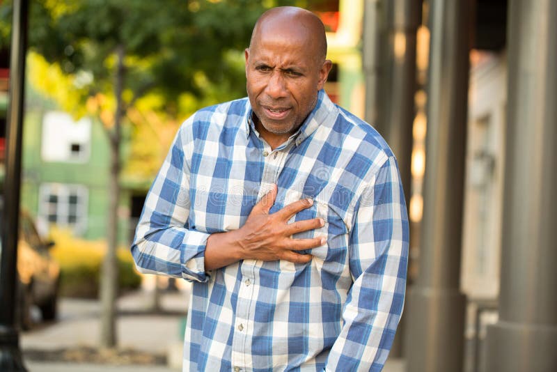 African American man having pains holding his chest.