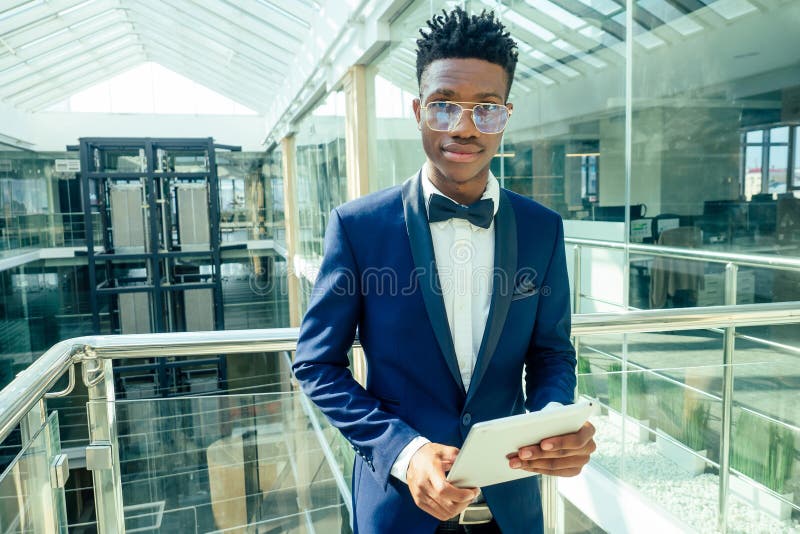 African American Man Holding Big Smartphone and Posing in Shoping Mall