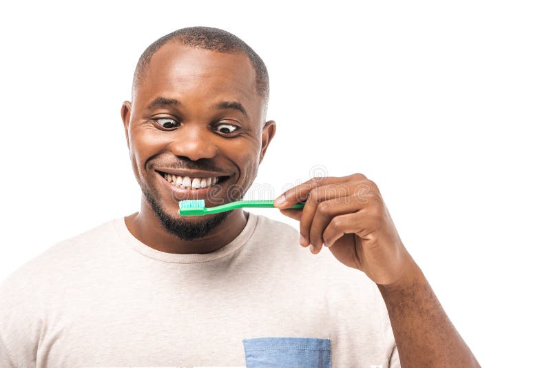 African American Man Looking at Toothbrush while Brushing Teeth ...