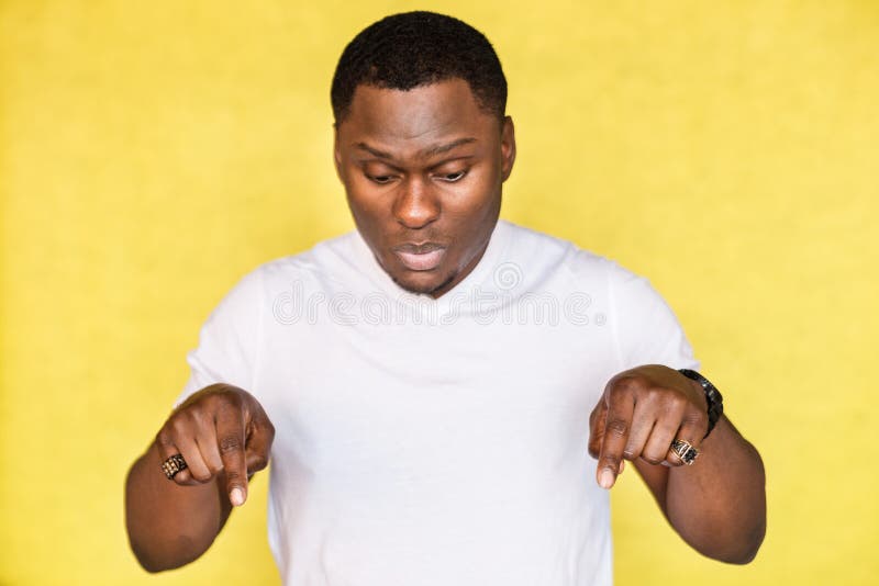 African American man looks down, expresses surprisement, indicate with forefingers at floor. royalty free stock image African American man looks down, expresses surprisement, indicate with forefingers at floor. royalty free stock image