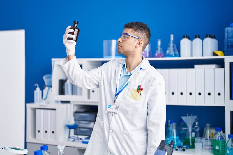 African american man scientist holding bottle at laboratory stock image