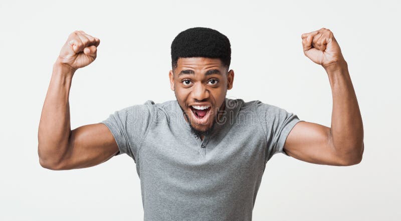Strong african-american man screaming and showing biceps at camera, white studio background