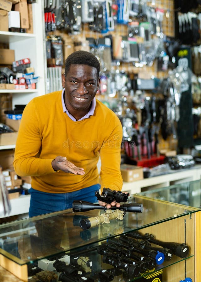Salesman in arms shop presenting rifle telescope stock images