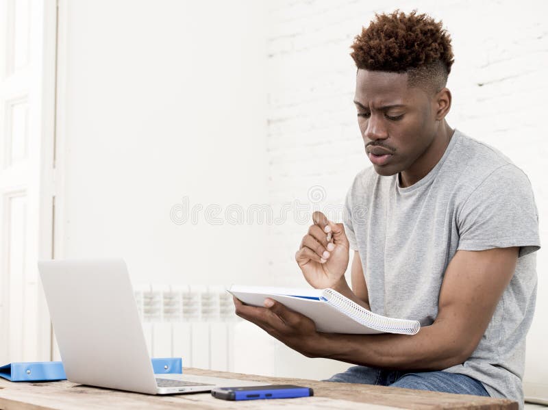 African american man sitting at home living room working with laptop computer and paperwork