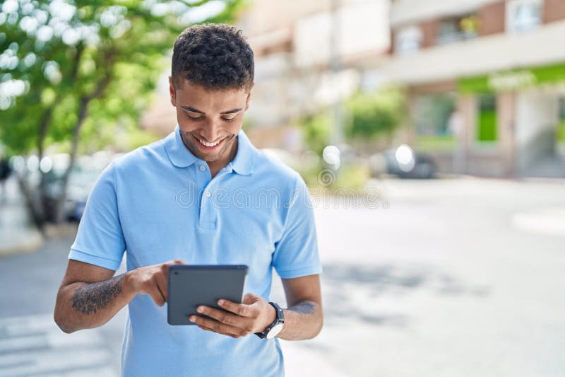 African american man smiling confident using touchpad at street royalty free stock image