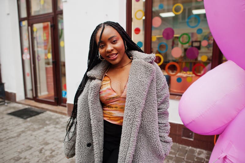 African american Millennium Lady nära uppblåsbar rosa teddy björn arkivfoton