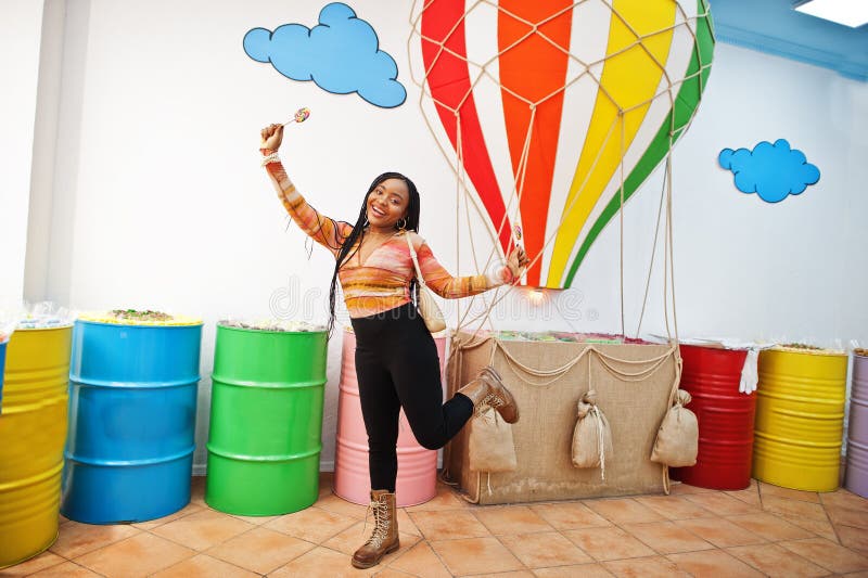 African american Millennium Lady på candy shop med lolipops arkivbild