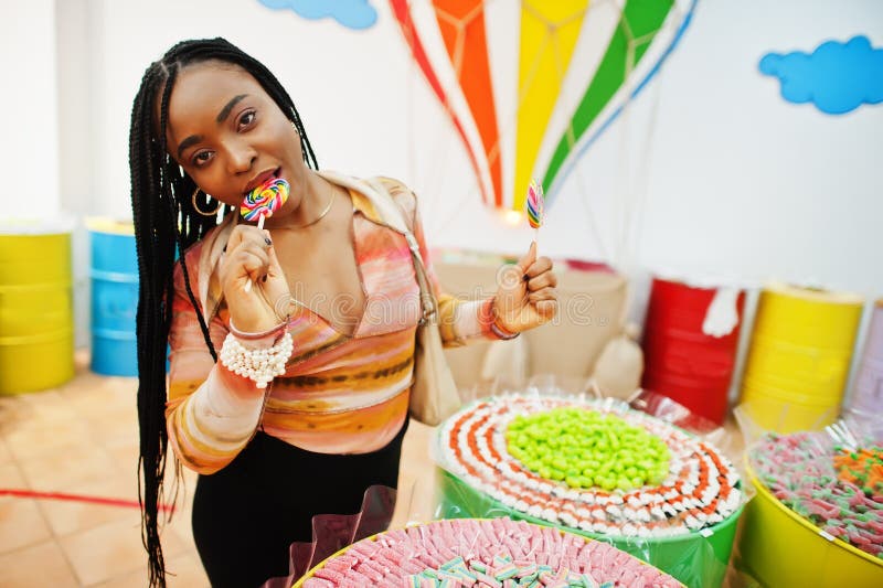African american Millennium Lady på candy shop med lolipops royaltyfri bild