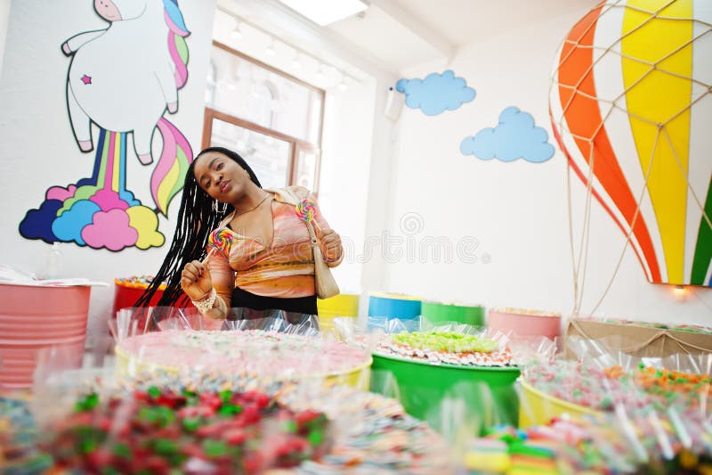 African american Millennium Lady på candy shop med lolipops royaltyfria bilder
