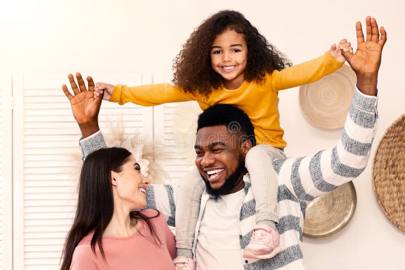 African American pappa håller dottern på axlarna arkivbild