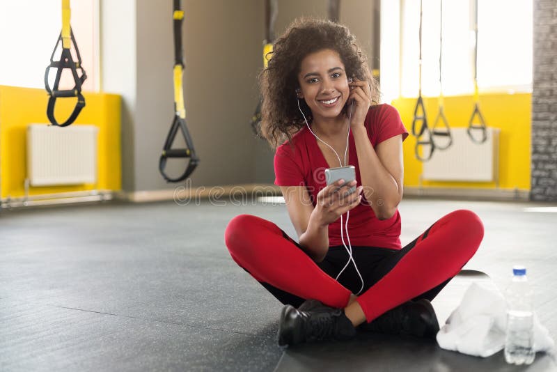 African-american sporty woman listening to music on smartphone in gym royalty free stock photo African-american sporty woman listening to music on smartphone in gym royalty free stock photo