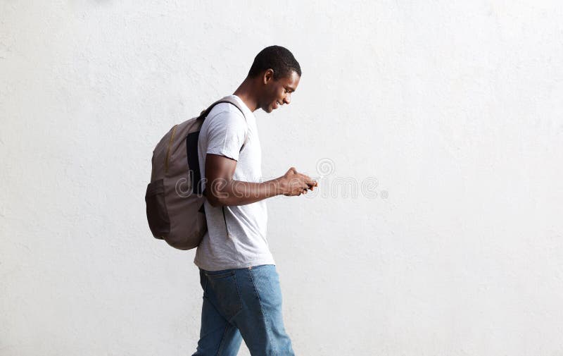 African american student walking with bag and mobile phone stock photo