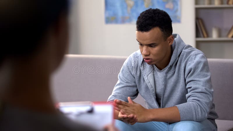 African american teenager suffering from loneliness and bullying, discrimination, stock photo