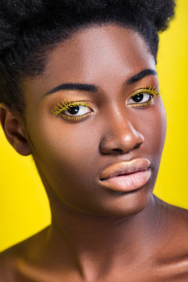 African American Woman With Bright Eyelashes Looking At Camera Isolated On Yellow Stock Image