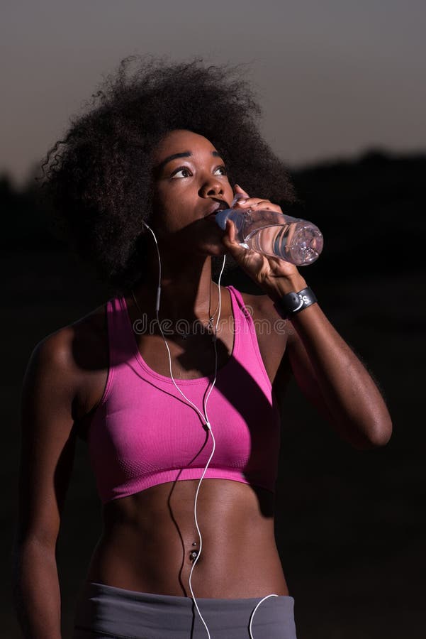 African american woman drinking water after jogging in nature royalty free stock image African american woman drinking water after jogging in nature royalty free stock image