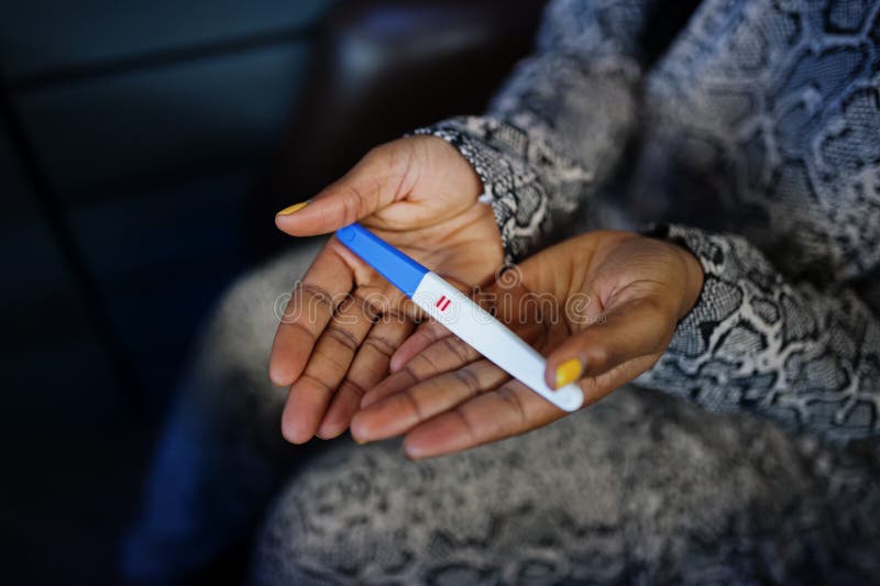 African American Woman Feeling Surprise Hold Pregnancy Test Stock Photo