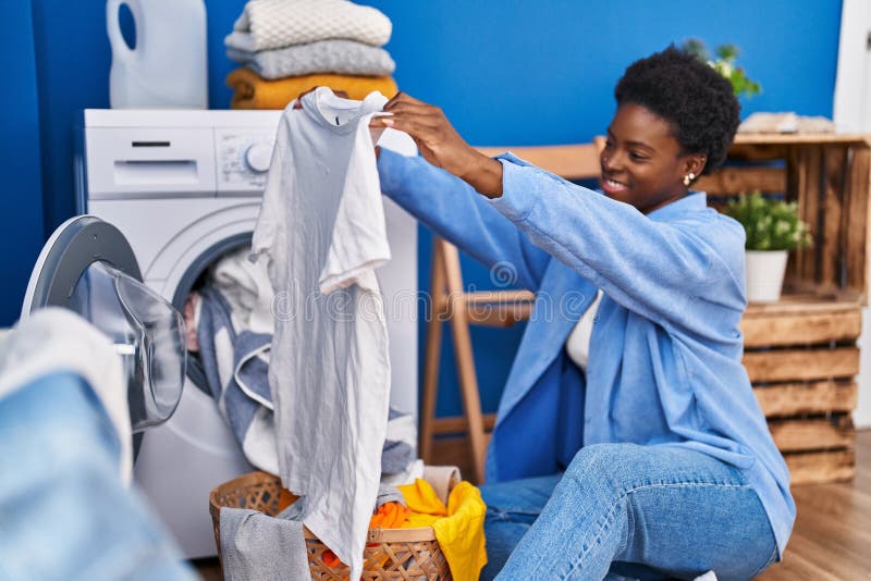 African American Woman Holding T Shirt Using Washing Machine at Laundry ...