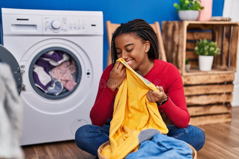 African American Woman Smelling Towel Washing Clothes at Laundry Room ...