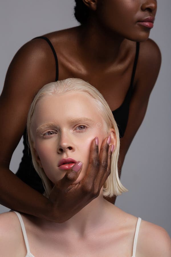 African-American woman standing and touching face of friend stock photo African-American woman standing and touching face of friend stock photo