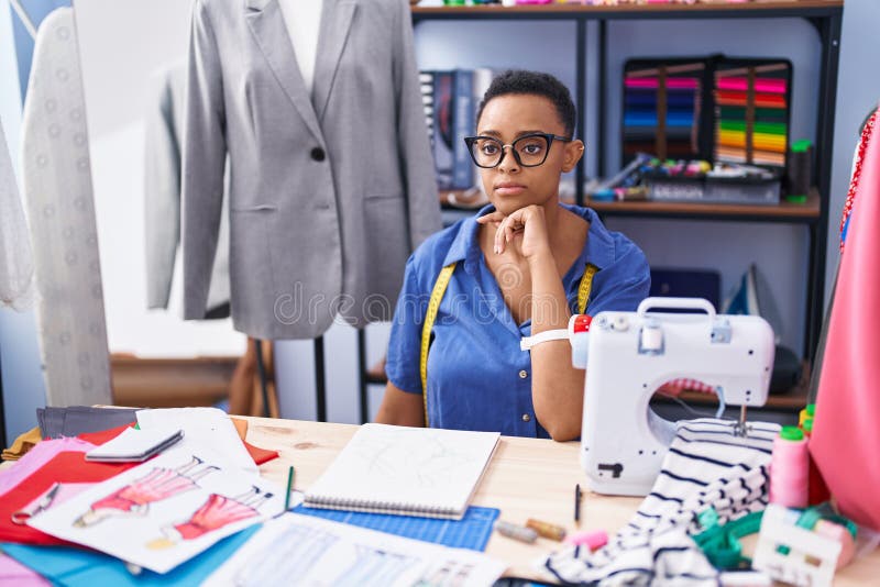 African American Woman Tailor Sitting with Serious Expression at Tailor ...