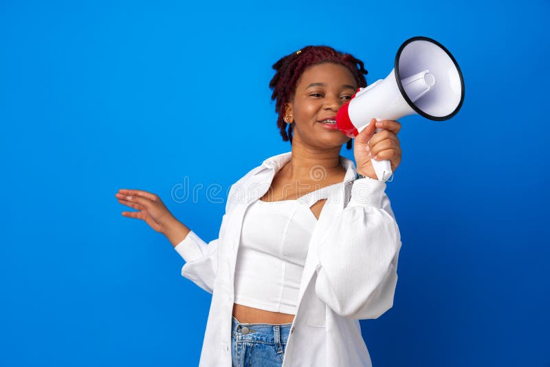 African american woman using megaphone against blue background, close up