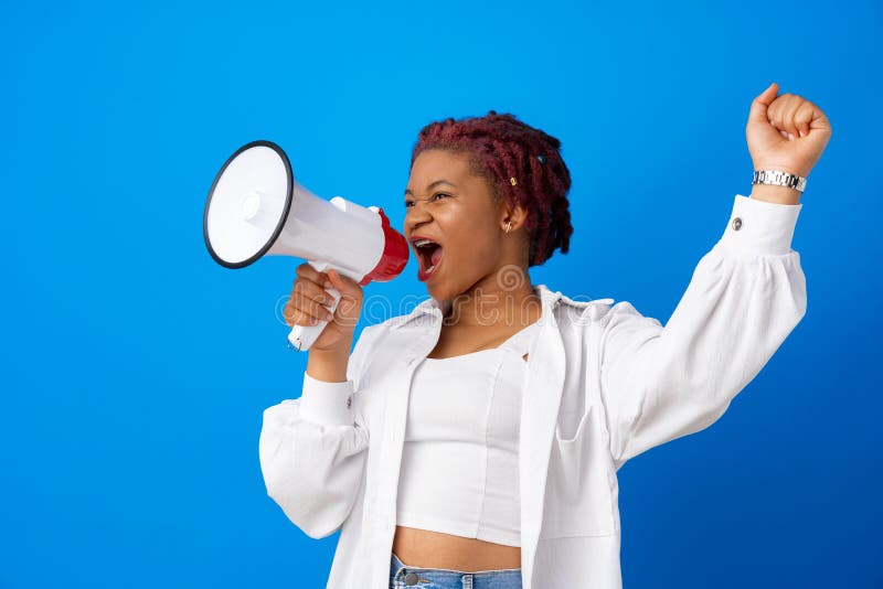 African american woman using megaphone against blue background, close up