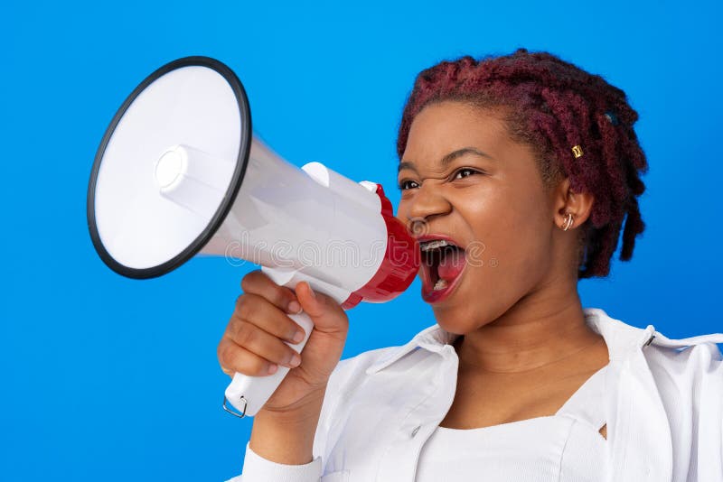 African american woman using megaphone against blue background, close up