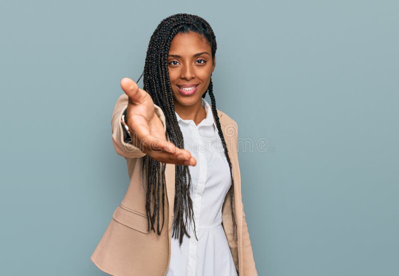 African american woman wearing business jacket smiling friendly offering handshake as greeting and welcoming royalty free stock images