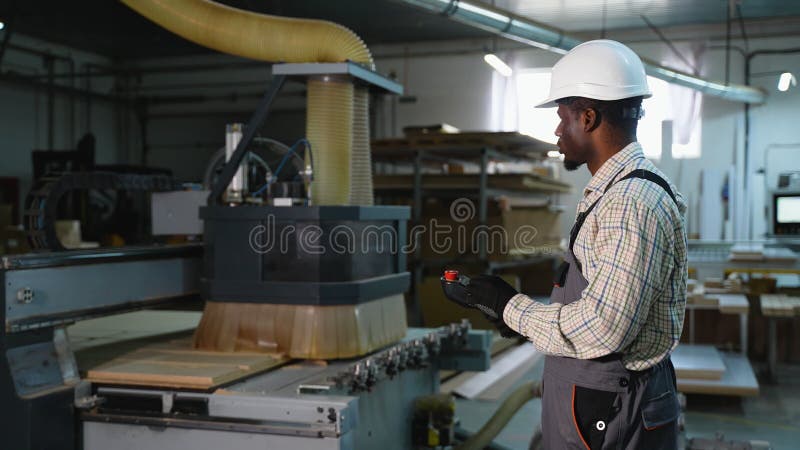 African American Workers Controls CNC Wood Cut Machine Remote stock video