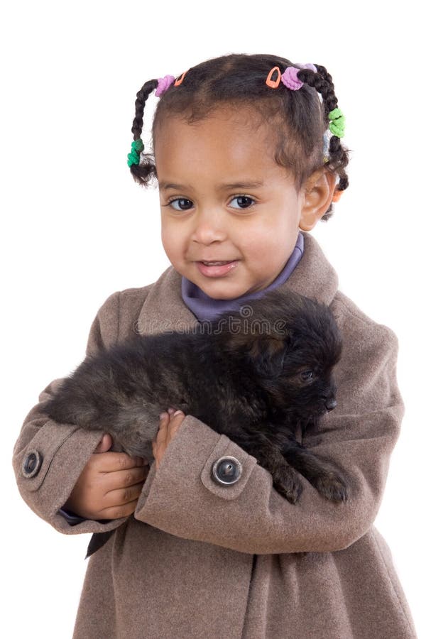 African baby holding a puppy on her arms