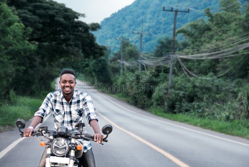 African Biker Rides a Motorcycle on the Highway Wearing a Helmet To ...