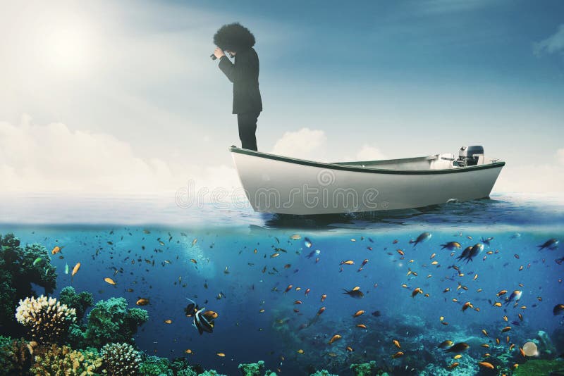 African businessman with binoculars on boat stock photo
