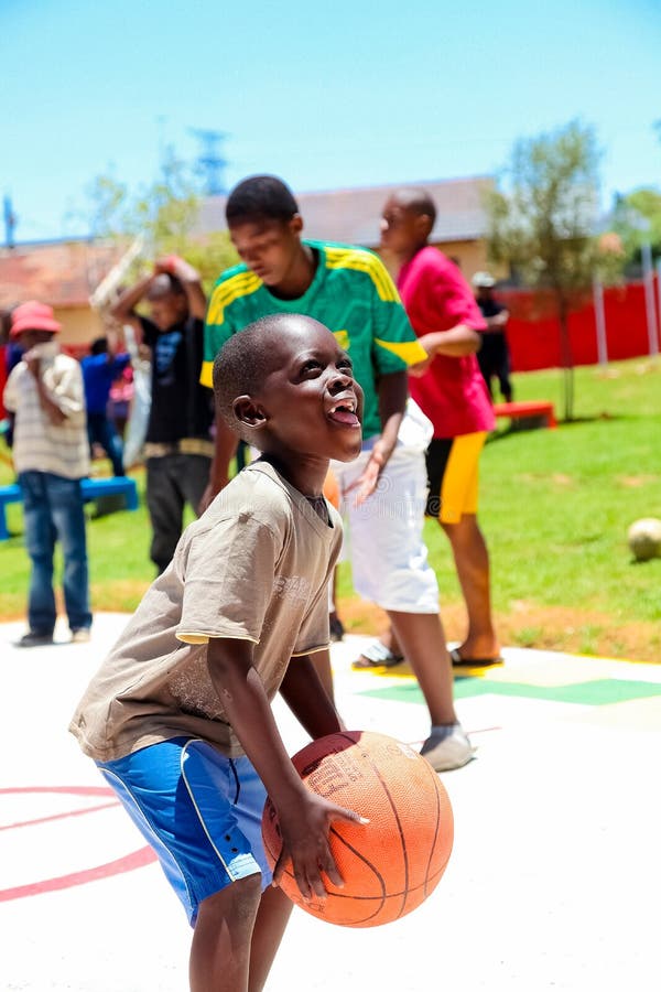 African children making a goal shot on public playground basketball court