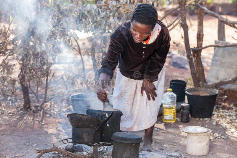 Al di fuori la cucina, una donna cucinando porridge un è un tradizionale pasto fatto cucinato un.