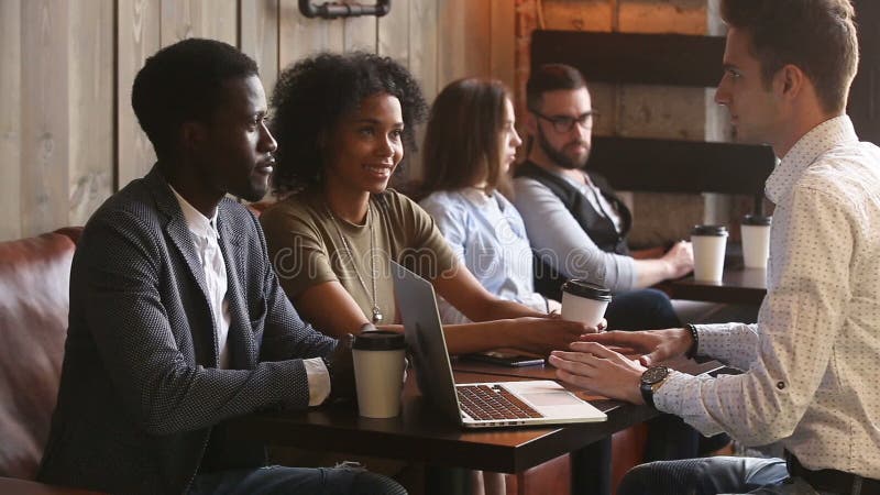 African couple making agreement handshaking caucasian lawyer in coffee house