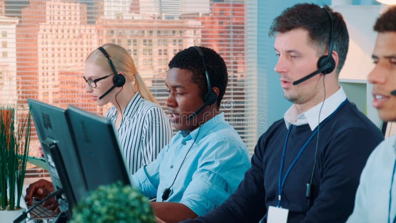 African customer service representative working on multiracial team of modern call center stock images