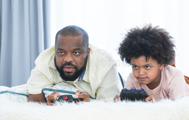 Father and Son Playing Video Games --- Image by © Royalty-…