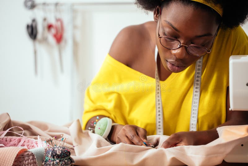 Sewing fabric with needle at seamstress workplace stock photos