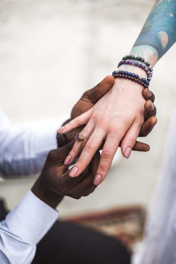 African groom wears wedding ring on the finger of Caucasian bride. Marriage closeup. boho wedding. boho style. happy royalty free stock image African groom wears wedding ring on the finger of Caucasian bride. Marriage closeup. boho wedding. boho style. happy royalty free stock image
