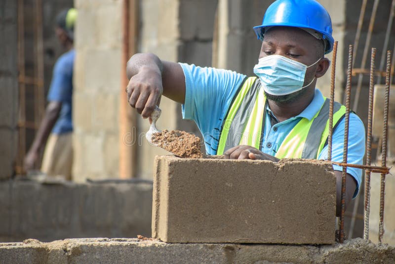 African Male Construction Worker with Helmet Working with Trowel on a
