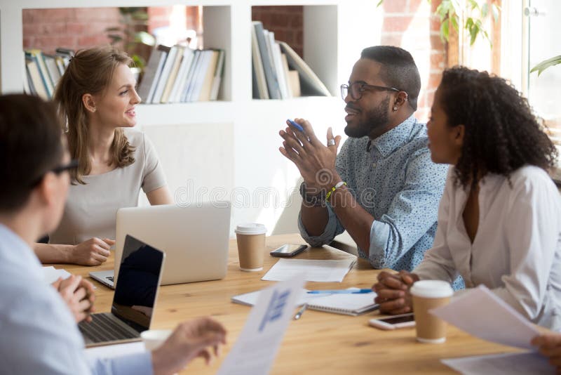 African male employee speaking sharing ideas at diverse team meeting