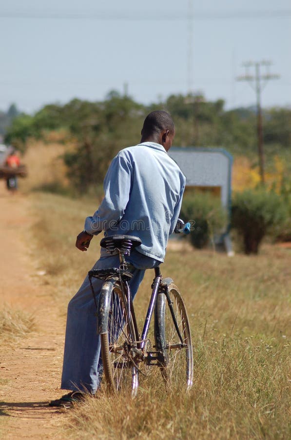 African Man Leaning on Bicycle Stock Photo - Image of leaning, track ...